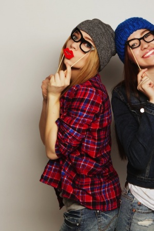 two stylish sexy hipster girls best friends ready for party, over gray background